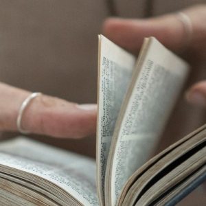 A photo of hands flipping through book pages.
