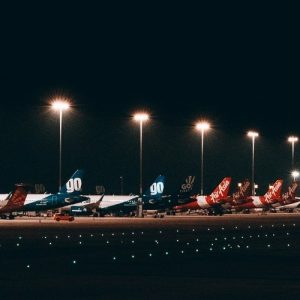 A long line of parked airplanes at night.