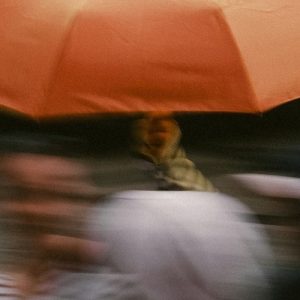 A blurred picture of someone holding an umbrella.
